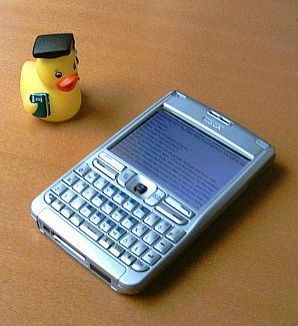 Rubber duck carrying a book, standing next to an ebook running on a Nokia E61